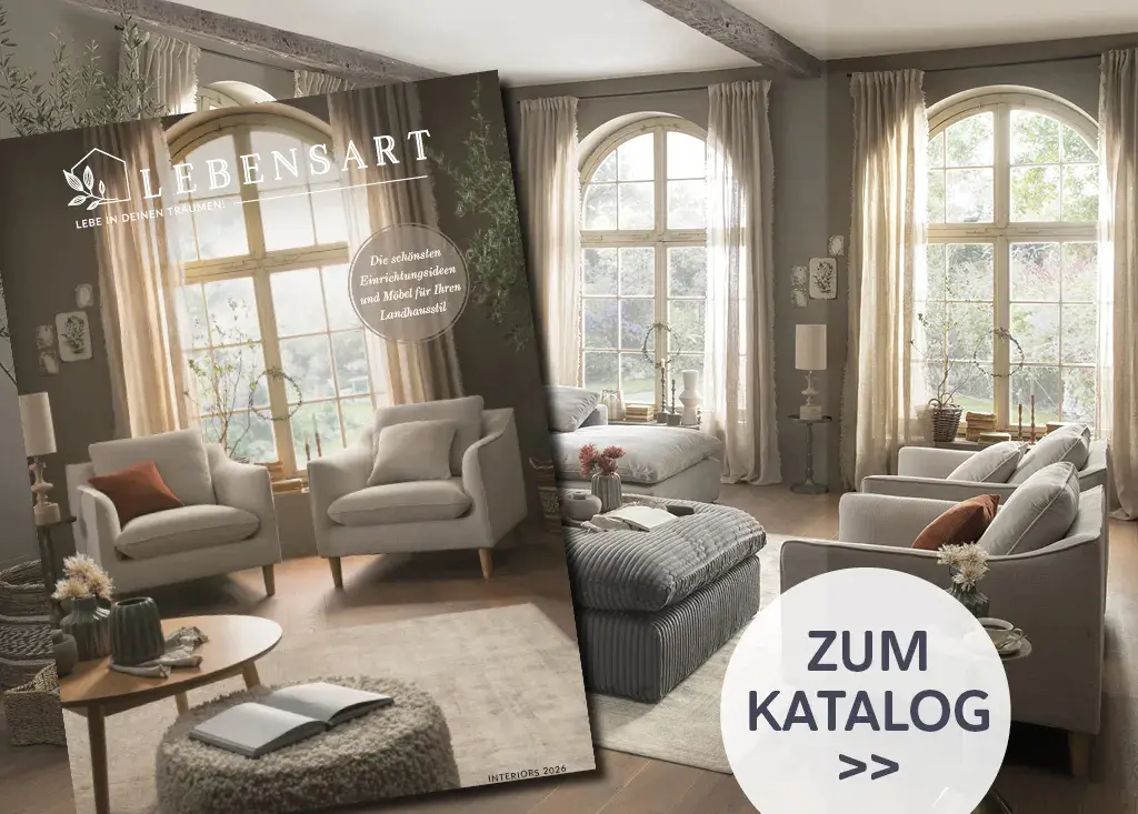 LEBENSART Einrichtungskatalog vor hellem Wohnzimmer im Landhausstil mit Sofa, Sessel und Naturtextilien, gemütliche Wohnideen für zeitloses Wohnen mit klassischen Möbeln.